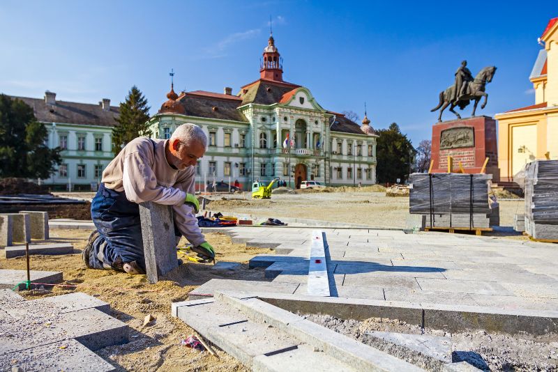 concrete worker installing paving with concrete slabs